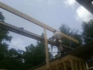 Carpenter setting a ridge beam over a new addition frame — Ice Dam Removal by Roofing Brothers in Taylorstown