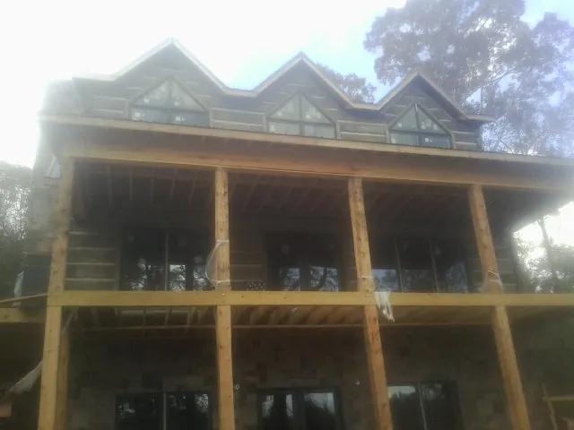 Dormers and porch framing on a large log home under construction — Roof Coating work by our crew in Taylorstown
