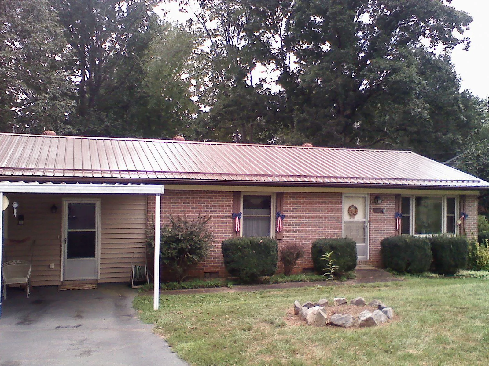 Bronze metal roof and carport on a brick ranch home — Roof Repair work by our crew in Taylorstown